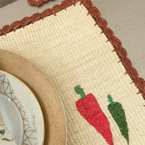 Straw placemat with handwoven chili peppers